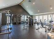 Thumbnail 31 of 82 - A spacious gym with a variety of equipment including a squat rack, bench, and weights.