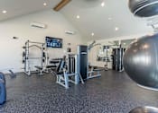 Thumbnail 33 of 82 - A spacious gym with a variety of equipment including a weight bench, a squat rack, a barbell, a medicine ball, a treadmill, a stationary bike, a rowing machine, a bench