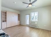Thumbnail 35 of 82 - A room with a ceiling fan and a window with an air conditioner unit.