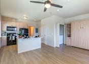 Thumbnail 36 of 82 - A kitchen with a white island and wooden floors.