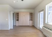 Thumbnail 37 of 82 - A room with a wooden floor and a window on the right side.