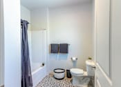 Thumbnail 41 of 82 - A bathroom with a toilet, a tub, and a shower curtain.