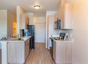 Thumbnail 43 of 82 - A kitchen with wooden cabinets and a black fridge.