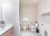 Thumbnail 47 of 82 - A white bathroom with a toilet, sink, and trash can.