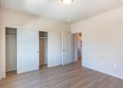 Thumbnail 49 of 82 - A room with white walls and wooden flooring with three white doors.