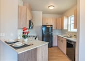 Thumbnail 50 of 82 - A kitchen with wooden cabinets and a black refrigerator.
