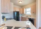 Thumbnail 51 of 82 - A modern kitchen with a black refrigerator and wooden cabinets.