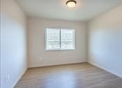 Thumbnail 55 of 82 - A room with a window and wooden flooring.