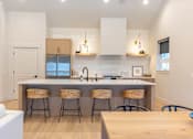 Thumbnail 7 of 82 - A kitchen with a white counter top and bar stools.