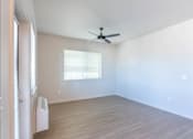 Thumbnail 68 of 82 - A room with a ceiling fan and a window with blinds.