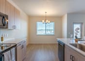Thumbnail 69 of 82 - A kitchen with wooden cabinets and a stainless steel sink.