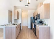 Thumbnail 73 of 82 - A kitchen with wooden cabinets and black appliances.