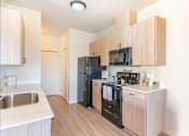 Thumbnail 74 of 82 - A kitchen with wooden cabinets and a black refrigerator.