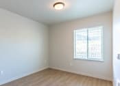 Thumbnail 75 of 82 - A room with a window and wooden flooring.