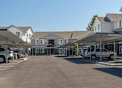 Thumbnail 12 of 51 - A parking lot with cars and a building in the background at Cascade Place Apartment Homes, Molalla