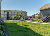 Thumbnail 16 of 51 - A red car is parked in a parking lot in front of a building at Cascade Place Apartment Homes, Molalla, OR