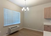 Thumbnail 18 of 51 - A room with a window, a chandelier, and a wall-mounted air conditioner at Cascade Place Apartment Homes, Molalla, 97038