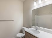 Thumbnail 21 of 51 - A white toilet sits next to a sink in a small bathroom at Cascade Place Apartment Homes, Oregon