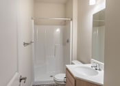Thumbnail 23 of 51 - A white bathroom with a toilet, sink, and shower at Cascade Place Apartment Homes, Oregon