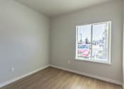 Thumbnail 24 of 51 - A room with a window showing a red car outside at Cascade Place Apartment Homes, Molalla, OR
