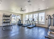 Thumbnail 6 of 51 - A spacious gym with treadmills, elliptical machines, and a weight rack at Cascade Place Apartment Homes, Oregon
