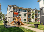 Thumbnail 11 of 36 - A playground with a slide is in front of a building at Forestplace Apartment Homes, Oregon