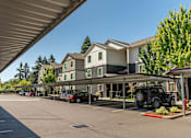 Thumbnail 15 of 36 - A parking lot with cars and a building in the background at Forestplace Apartment Homes, Oregon, 97116