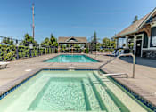 Thumbnail 19 of 36 - A pool with a diving board and a small building in the background at Forestplace Apartment Homes, Forest Grove, OR