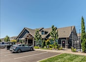 Thumbnail 24 of 36 - A silver car is parked in a parking lot in front of a building at Forestplace Apartment Homes, Forest Grove, 97116