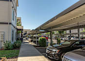 Thumbnail 5 of 36 - A parking lot with cars and a building in the background at Forestplace Apartment Homes, Forest Grove