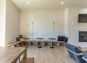 Thumbnail 11 of 25 - A modern living room with a wooden table and blue chairs at Northplace Apartment Homes, Salem, OR, 97305