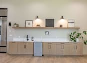 Thumbnail 12 of 25 - A kitchen with a white countertop and wooden cabinets at Northplace Apartment Homes, Oregon