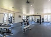 Thumbnail 14 of 25 - A spacious gym with a variety of equipment including dumbbells, weight machines, and a bench press at Northplace Apartment Homes, Salem, Oregon
