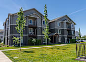 Thumbnail 18 of 25 - A modern apartment building with a well-maintained lawn in front at Northplace Apartment Homes, Salem, OR