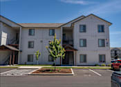 Thumbnail 21 of 25 - A white apartment building with a red car parked in front at Northplace Apartment Homes, Salem, 97305