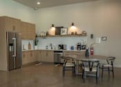 Thumbnail 6 of 25 - A modern kitchen with a refrigerator, sink, and dining table at Northplace Apartment Homes, Salem