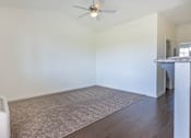 Thumbnail 1 of 72 - A room with a ceiling fan and a carpeted floor at Riverplace Apartment Homes, Independence