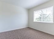 Thumbnail 12 of 72 - A room with a window and carpeted floor at Riverplace Apartment Homes, Independence, OR, 97351
