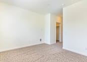 Thumbnail 13 of 72 - A large, empty room with carpeted flooring and white walls at Riverplace Apartment Homes, Oregon