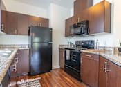 Thumbnail 17 of 72 - A kitchen with a black refrigerator and black oven at Riverplace Apartment Homes, Independence, OR