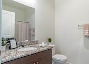Thumbnail 20 of 72 - A bathroom with a white toilet and a marble counter top at Riverplace Apartment Homes, Independence, Oregon