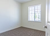 Thumbnail 21 of 72 - A room with a carpeted floor and a window with blinds at Riverplace Apartment Homes, Independence, 97351