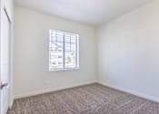 Thumbnail 23 of 72 - A room with a window and carpeted floor at Riverplace Apartment Homes, Independence, Oregon
