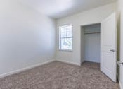 Thumbnail 26 of 72 - A room with a carpeted floor and a window with blinds at Riverplace Apartment Homes, Independence, OR