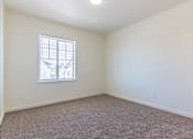 Thumbnail 28 of 72 - A room with a carpeted floor and a window at Riverplace Apartment Homes, Oregon, 97351