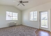 Thumbnail 34 of 72 - A room with a ceiling fan and two windows at Riverplace Apartment Homes, Independence