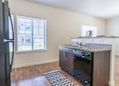 Thumbnail 39 of 72 - A kitchen with a refrigerator, oven, and microwave at Riverplace Apartment Homes, Independence, Oregon