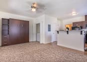 Thumbnail 42 of 72 - A spacious living room with a ceiling fan and a kitchen area with a microwave and oven at Riverplace Apartment Homes, Independence, OR