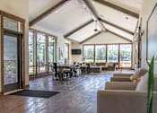 Thumbnail 46 of 72 - A living room with a stone wall and a ceiling fan at Riverplace Apartment Homes, Independence, 97351