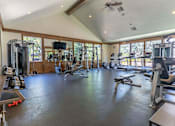 Thumbnail 51 of 72 - A spacious home gym with a variety of exercise equipment at Riverplace Apartment Homes, Oregon